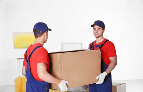 Professional movers loading furniture into a truck for a Queens Park move