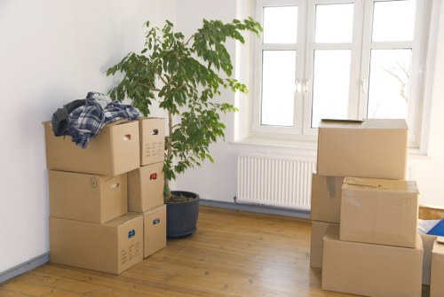 Professional movers carrying household items from a flat in Queens Park