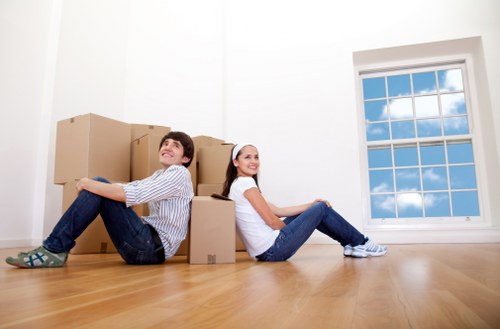 Removalists handling furniture in a Queens Park home with tight access