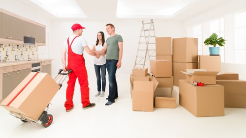 Movers carrying furniture from a Queens Park flat with stair access